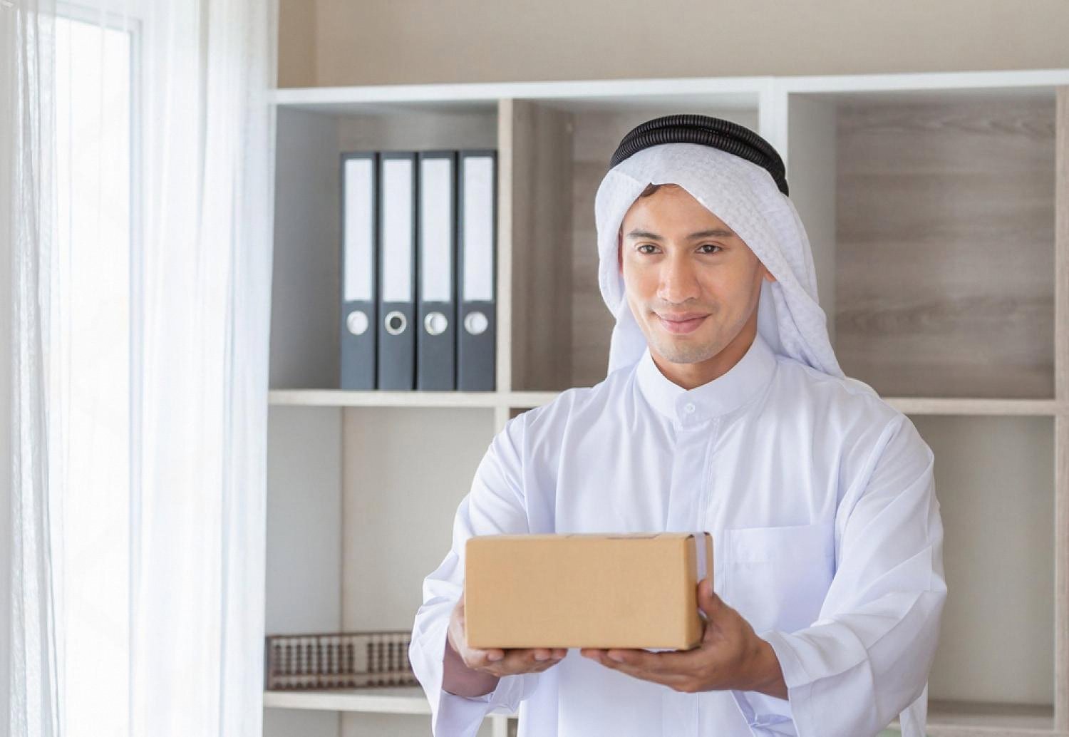 Emirati entrepreneur holding a product box, testing demand in the UAE market